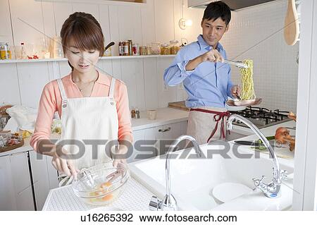 Stock Image - Young couple at kitchen . Fotosearch
