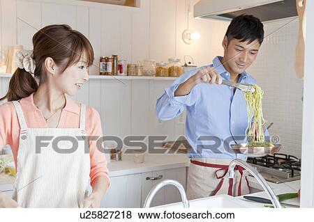 Stock Photo - Young couple at kitchen . Fotosearch