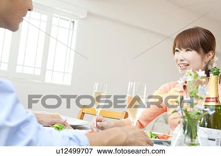 Stock Photo - Young couple eating dinner. Fotosearch