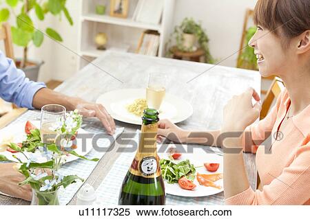 Stock Photography - Young couple eating dinner. Fotosearch