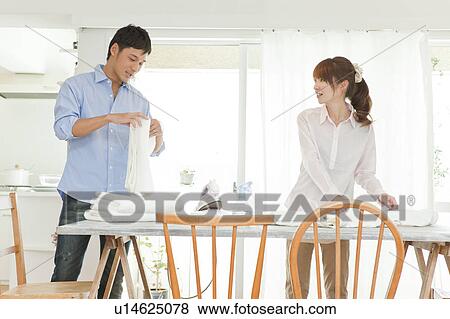 Young couple folding laundry View Large Photo Image Stock Photo - Young couple folding laundry. Fotosearch