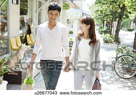 Young couple holding hands and walking View Large Photo Image Stock Image - Young couple holding hands and walking. Fotosearch
