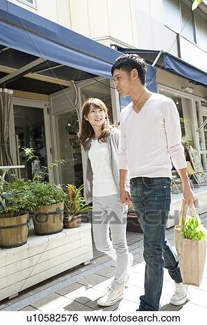 Stock Photograph - Young couple holding hands and walking. Fotosearch