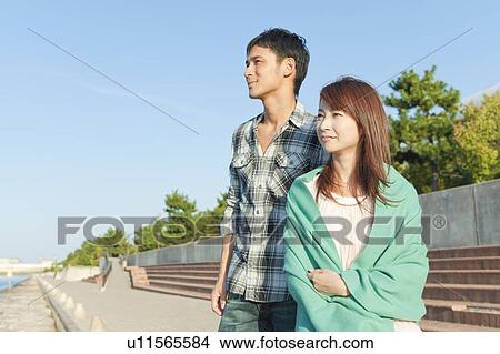 Young couple looking away, Hyogo Prefecture, Honshu, Japan View Large Photo Image Picture - Young couple looking away, Hyogo Prefecture, Honshu, Japan. Fotosearch