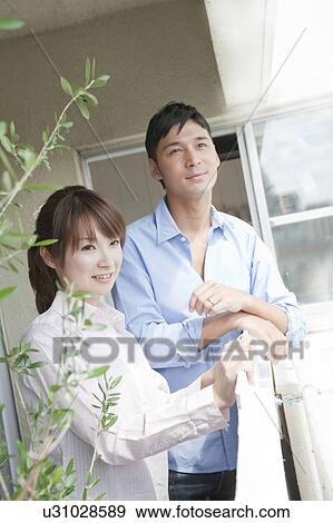 Young couple looking out the balcony View Large Photo Image Stock Photo - Young couple looking out the balcony. Fotosearch