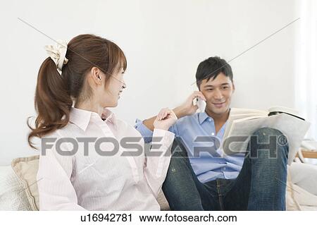 Young couple relaxing on sofa View Large Photo Image Stock Image - Young couple relaxing on sofa. Fotosearch