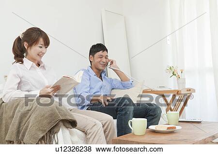 Young couple relaxing on sofa View Large Photo Image Stock Photo - Young couple relaxing on sofa. Fotosearch