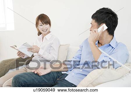 Young couple relaxing on sofa View Large Photo Image Stock Photo - Young couple relaxing on sofa. Fotosearch