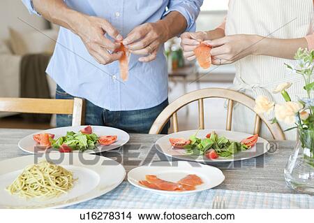 Young couple serving salad View Large Photo Image Picture - Young couple serving salad. Fotosearch