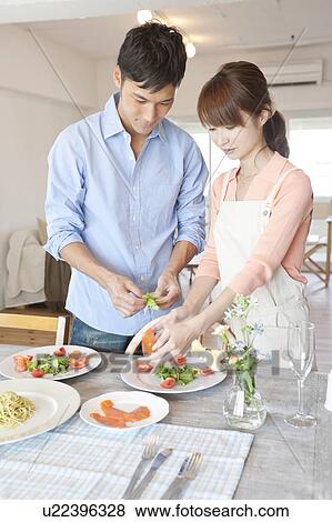 Young couple serving salad View Large Photo Image Stock Photo - Young couple serving salad. Fotosearch