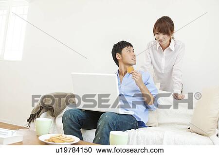 Stock Image - Young couple using laptop. Fotosearch