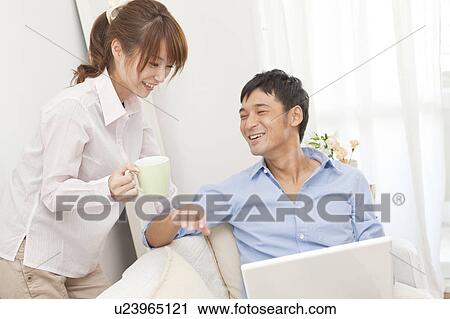 Stock Image - Young couple using laptop. Fotosearch