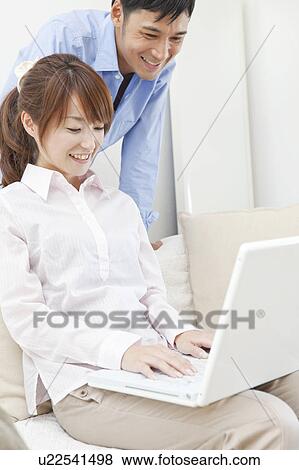 Young couple using laptop View Large Photo Image Stock Photo - Young couple using laptop. Fotosearch