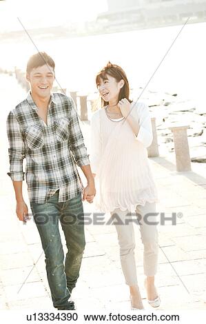 Stock Image - Young couple walking by the river, Hyogo Prefecture, Honshu, Japan. Fotosearch