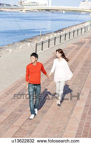 Stock Image - Young couple walking by the river, Hyogo Prefecture, Honshu, Japan. Fotosearch