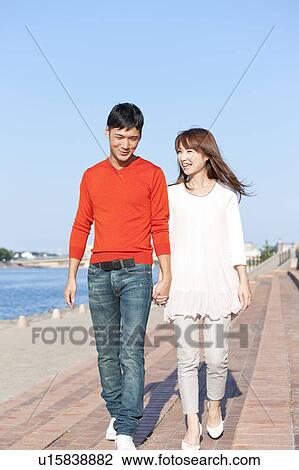 Stock Image - Young couple walking by the river, Hyogo Prefecture, Honshu, Japan. Fotosearch
