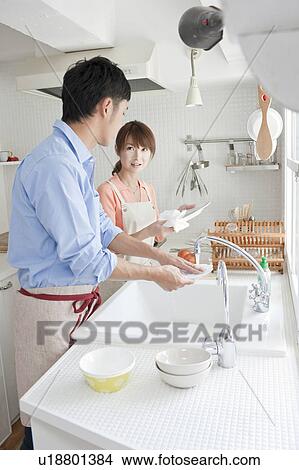 Young couple washing dishes View Large Photo Image Picture - Young couple washing dishes. Fotosearch