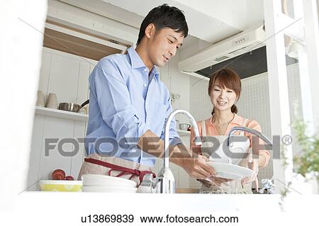 Young couple washing dishes View Large Photo Image Stock Photo - Young couple washing dishes. Fotosearch