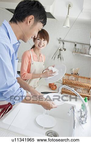 Stock Photography - Young couple washing dishes. Fotosearch