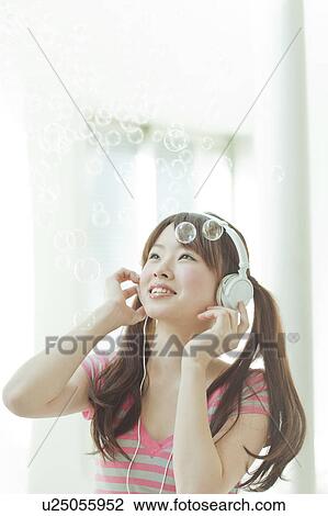 Young Japanese woman listening to music View Large Photo Image Stock Image - Young Japanese woman listening to music. Fotosearch