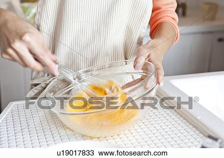 Young woman beating an egg View Large Photo Image Stock Image - Young woman beating an egg. Fotosearch