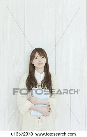 Stock Photo - Young woman by wall. Fotosearch
