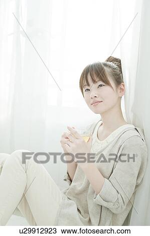 Stock Image - Young Woman Having Tea. Fotosearch