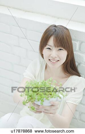 Young woman Holding Houseplant View Large Photo Image Stock Photo - Young woman Holding Houseplant. Fotosearch