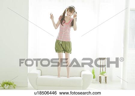 Stock Photograph - Young woman listening to music. Fotosearch