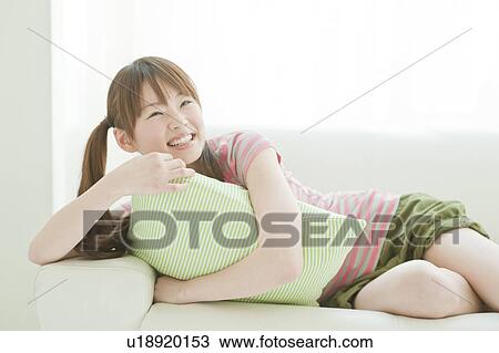 Young woman lying down on sofa View Large Photo Image Stock Image - Young woman lying down on sofa. Fotosearch