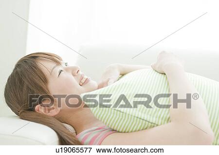 Young woman lying on sofa View Large Photo Image Stock Photo - Young woman lying on sofa. Fotosearch