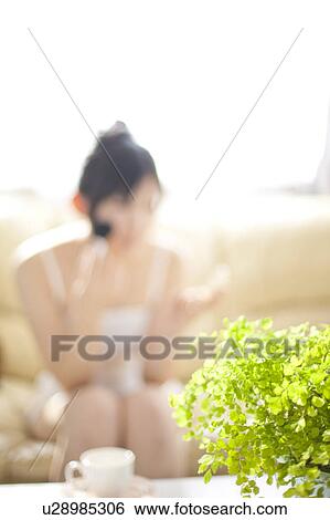 Stock Photograph - Young woman putting make-up on. Fotosearch