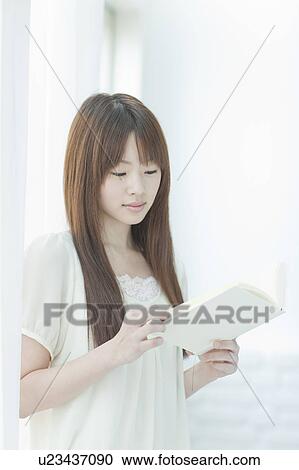 Young woman reading a book View Large Photo Image Stock Image - Young woman reading a book. Fotosearch
