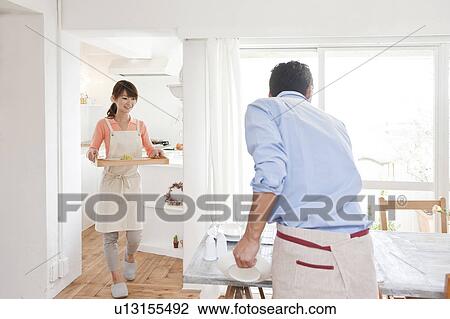 Young woman serving pasta and young man setting the table View Large Photo Image Stock Image - Young woman serving pasta and young man setting the table. Fotosearch