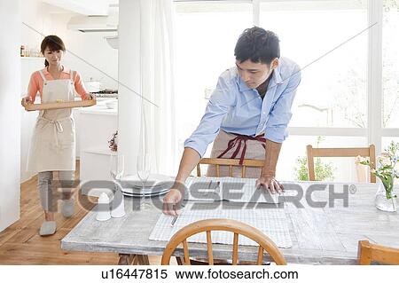 Young woman serving pasta and young man setting the table View Large Photo Image Stock Photography - Young woman serving pasta and young man setting the table. Fotosearch