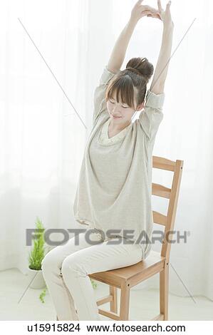 Picture - Young Woman Stretching on Chair. Fotosearch