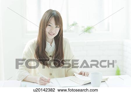 Young woman studying at desk View Large Photo Image Stock Image - Young woman studying at desk. Fotosearch