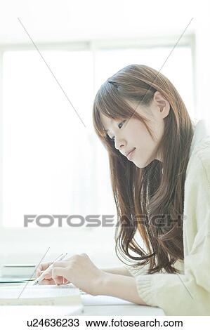 Young woman studying at desk View Large Photo Image Stock Image - Young woman studying at desk. Fotosearch