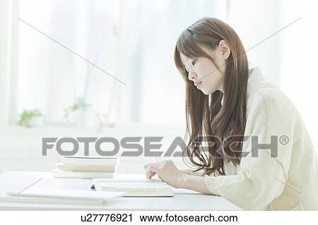 Young woman studying at desk View Large Photo Image Stock Image - Young woman studying at desk. Fotosearch