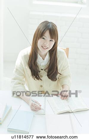 Young woman studying at desk View Large Photo Image Stock Photo - Young woman studying at desk. Fotosearch
