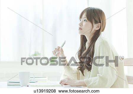 Stock Photo - Young woman studying at desk. Fotosearch