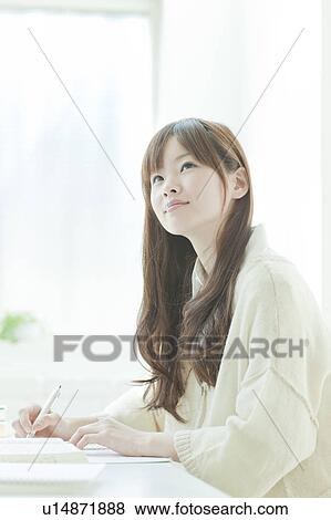 Young woman studying at desk View Large Photo Image Stock Photo - Young woman studying at desk. Fotosearch