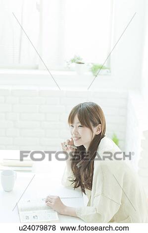 Young woman studying at desk View Large Photo Image Stock Photo - Young woman studying at desk. Fotosearch
