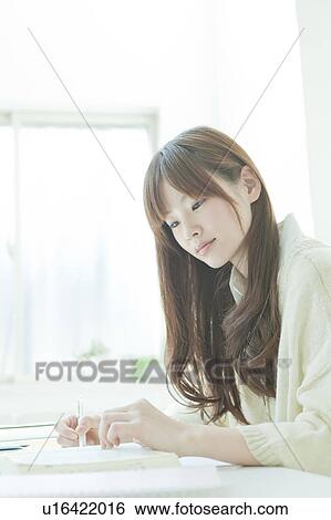 Young woman studying at desk View Large Photo Image Stock Photograph - Young woman studying at desk. Fotosearch