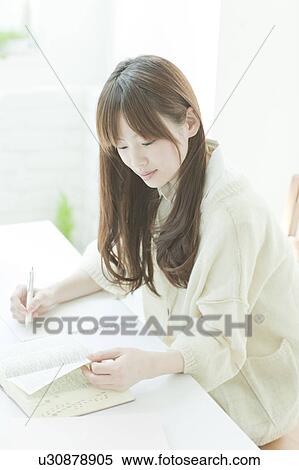 Young woman studying at desk View Large Photo Image Stock Photography - Young woman studying at desk. Fotosearch