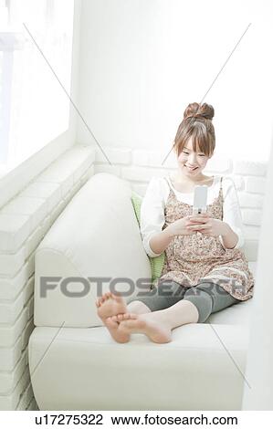 Young Woman Text Messaging on Sofa View Large Photo Image Stock Image - Young Woman Text Messaging on Sofa. Fotosearch