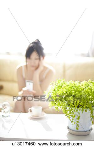 Stock Image - Young woman text messaging. Fotosearch