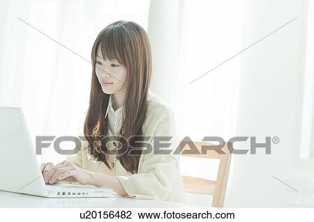 Young woman using laptop View Large Photo Image Stock Image - Young woman using laptop. Fotosearch