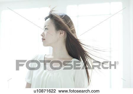 Stock Image - Young woman with hair fluttering. Fotosearch