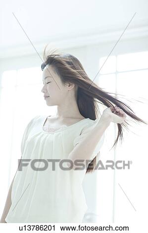 Young woman with hair fluttering View Large Photo Image Stock Image - Young woman with hair fluttering. Fotosearch